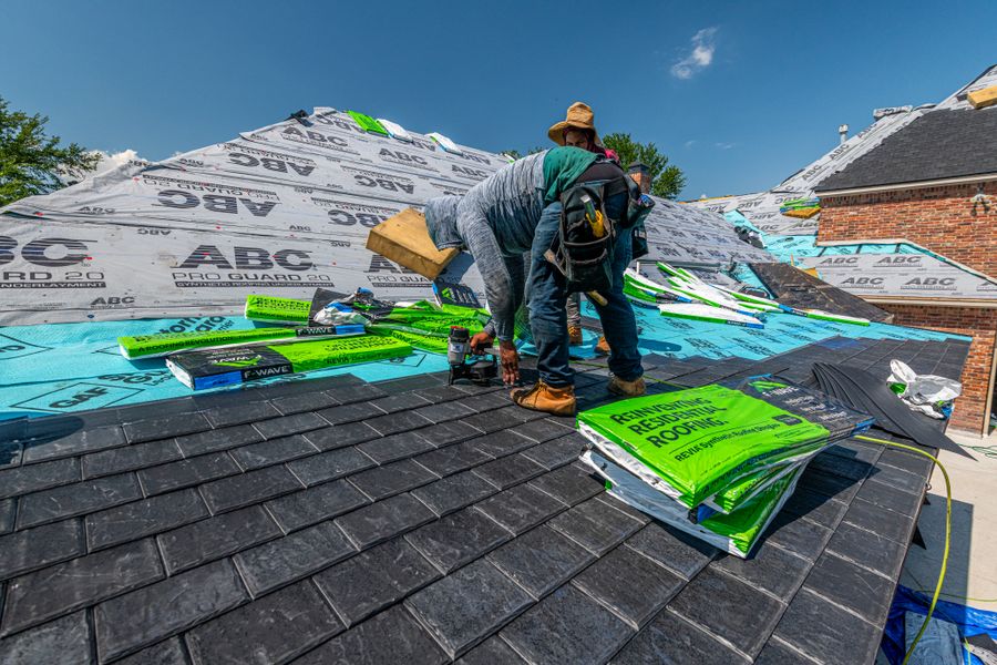 Workers installing a synthetic slate roof
