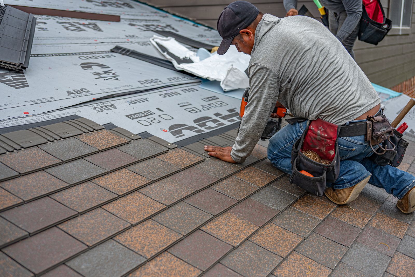 Roofer laying asphalt shingles